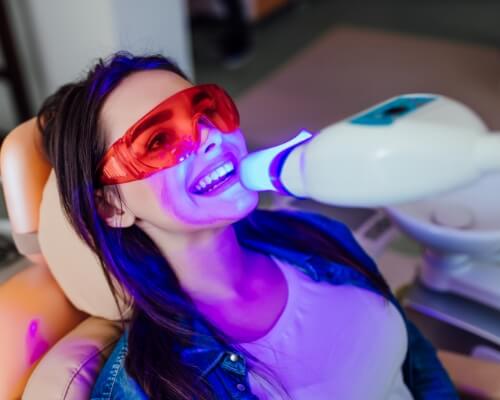 Woman in dental chair getting her teeth professionally whitened