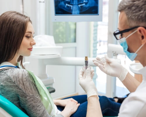 Dentist showing a dental implant to a patient
